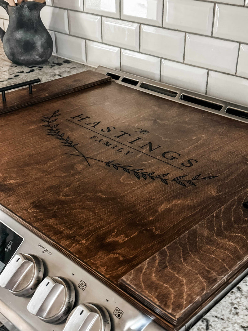 Personalized family name stove cover, warm brown + dark script "Hastings"
