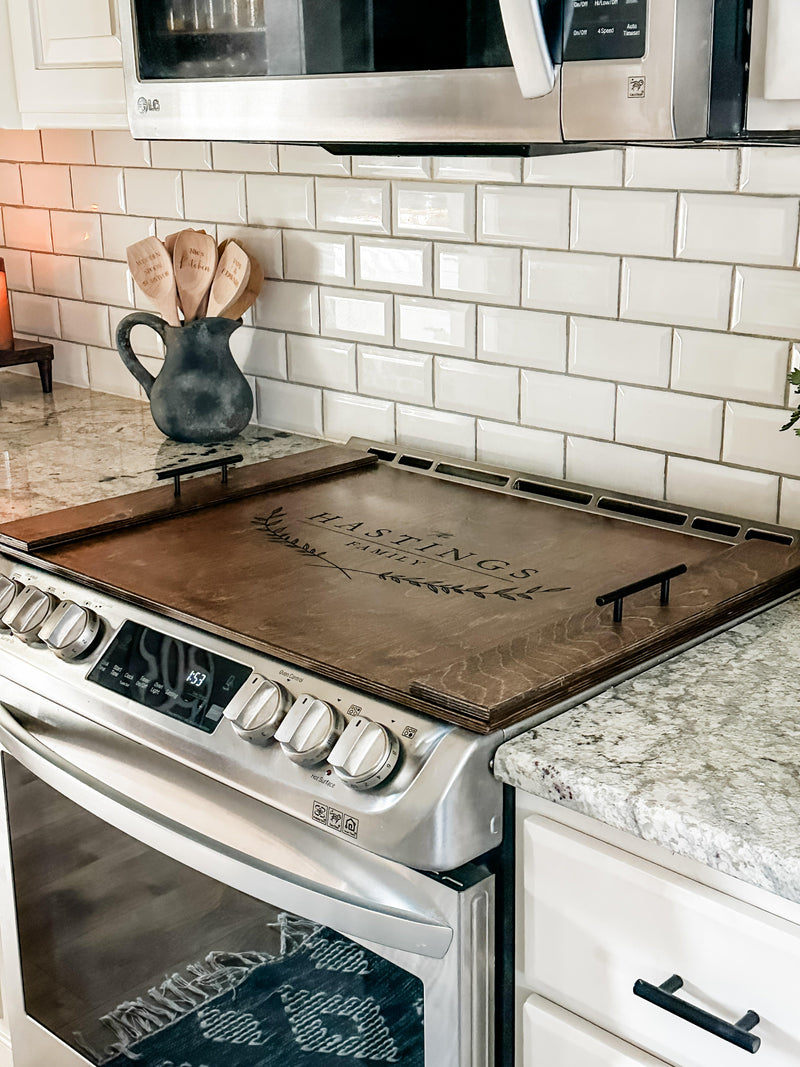 Personalized family name stove cover, warm brown + dark script "Hastings"