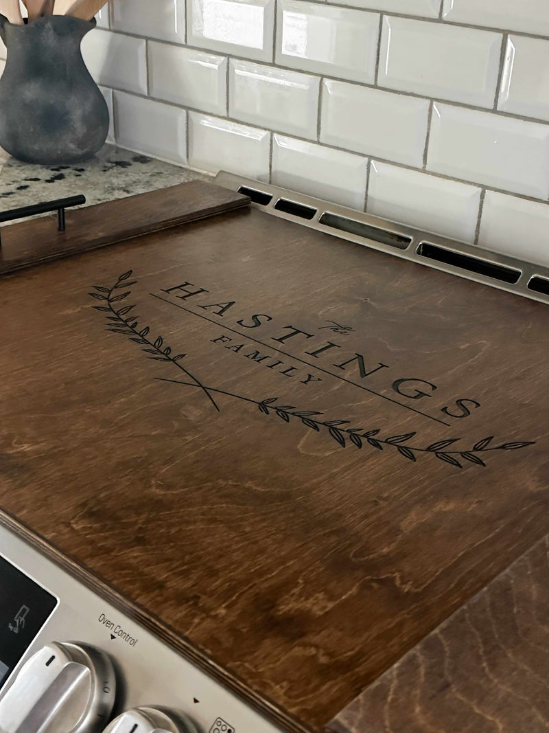 Personalized family name stove cover, warm brown + dark script "Hastings"