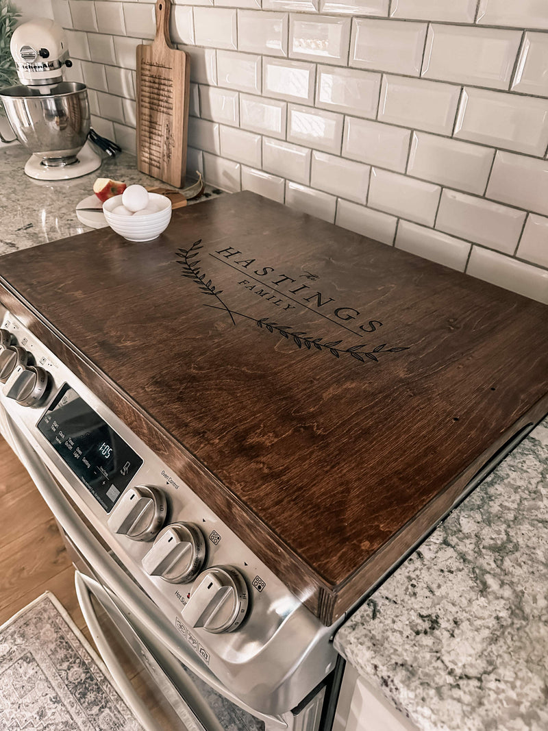 Personalized family name stove cover, warm brown + dark script "Hastings"