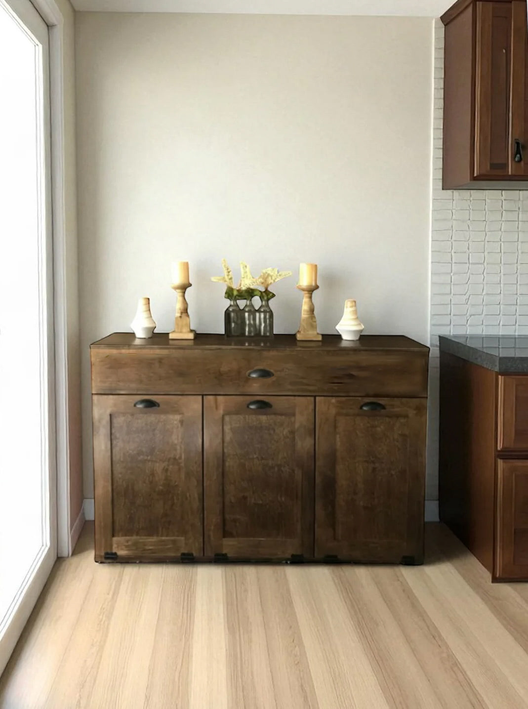 Triple tilt out trash cabinet with storage drawer in warm brown stain