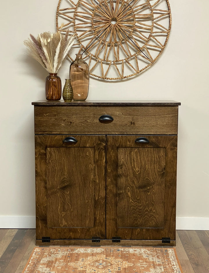 Freestanding trash cabinet with a storage drawer in dark brown stain