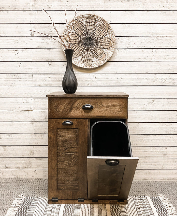 Counter high, slim trash cabinet design. Includes a storage drawer in dark brown