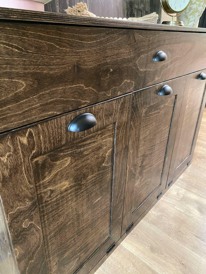 Furniture style triple tilt out trash cabinet in dark brown with a storage drawer