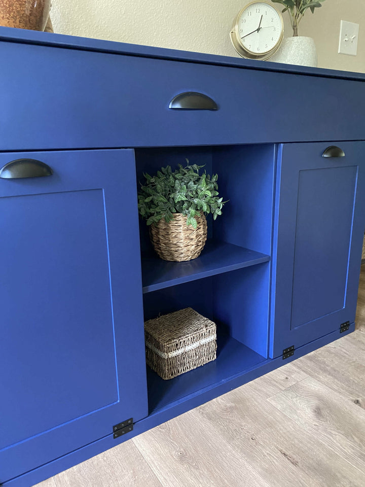 Triple trash cabinet with a storage drawer and open shelving in blue