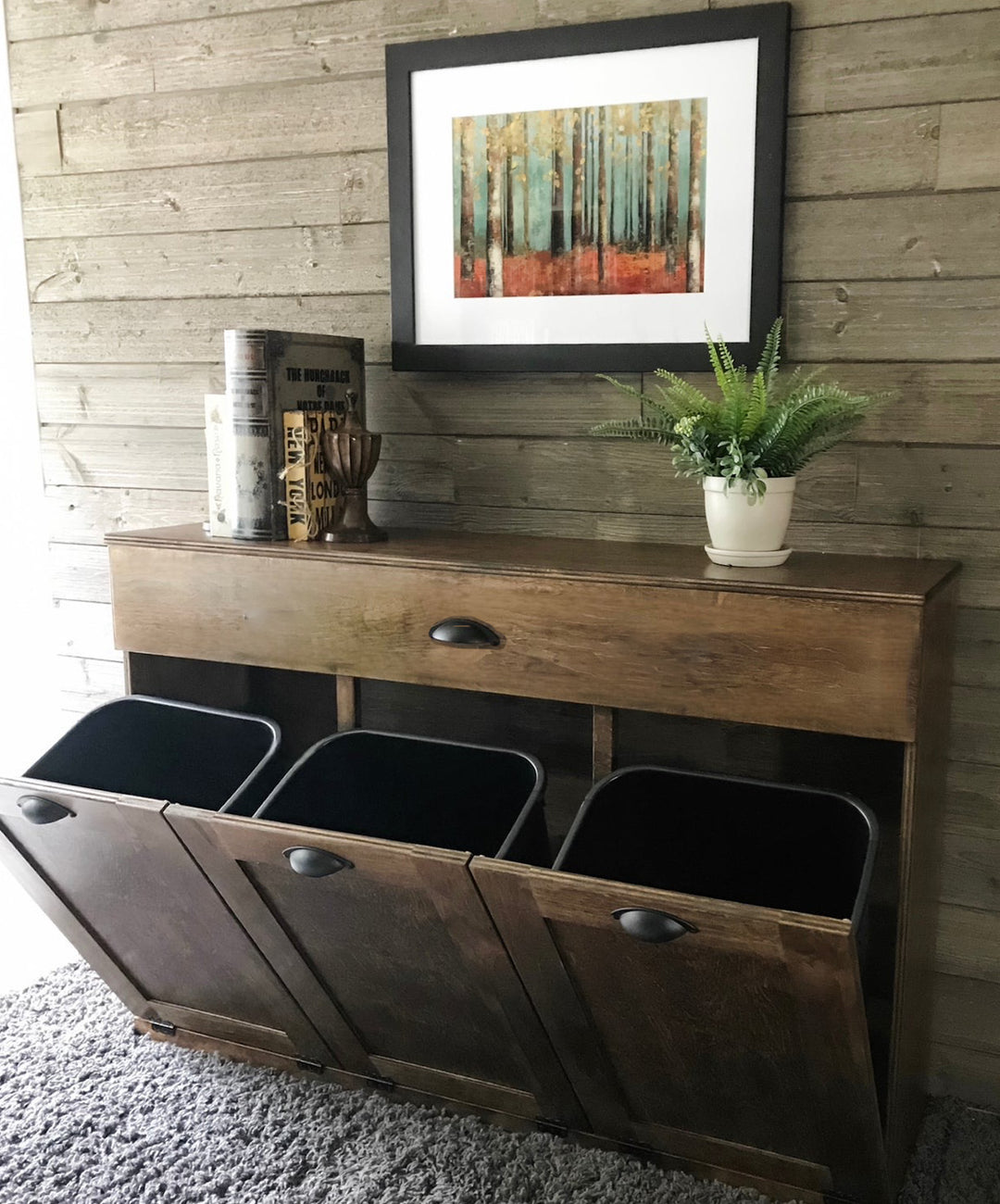 Triple tilt out trash cabinet with storage drawer in warm brown stain