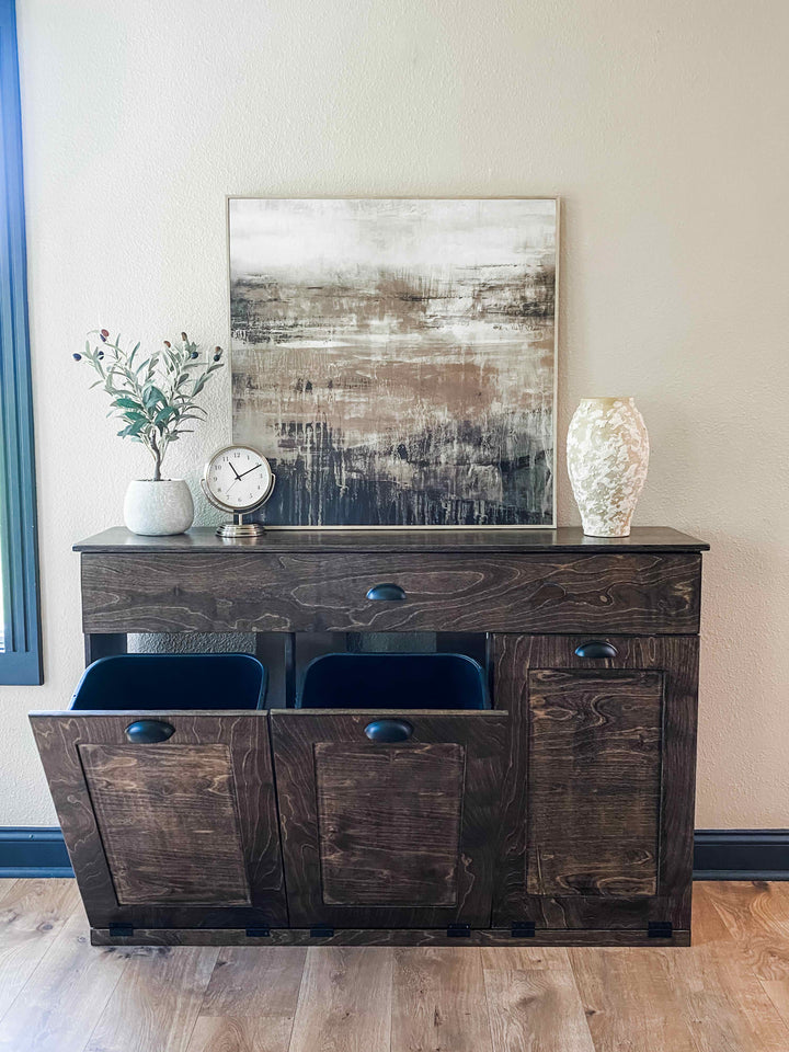 Furniture style triple tilt out trash cabinet in dark brown with a storage drawer