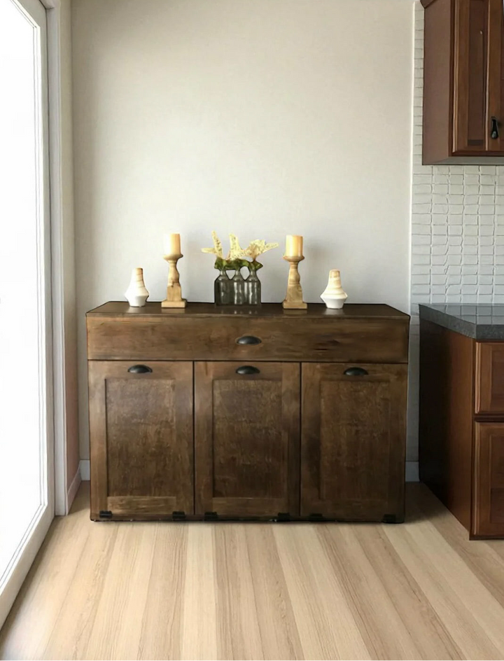 Triple tilt out trash cabinet with storage drawer in warm brown stain