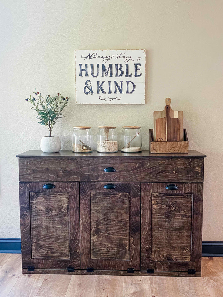 Furniture style triple tilt out trash cabinet in dark brown with a storage drawer