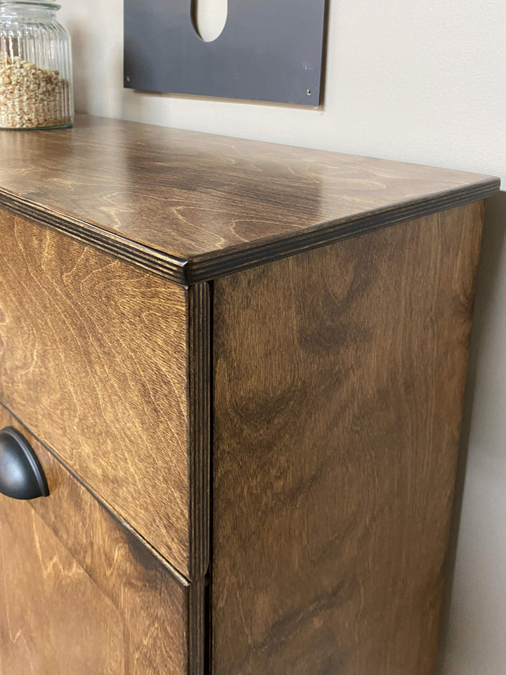 Triple tilt-out with a storage drawer and open shelving in warm brown stain