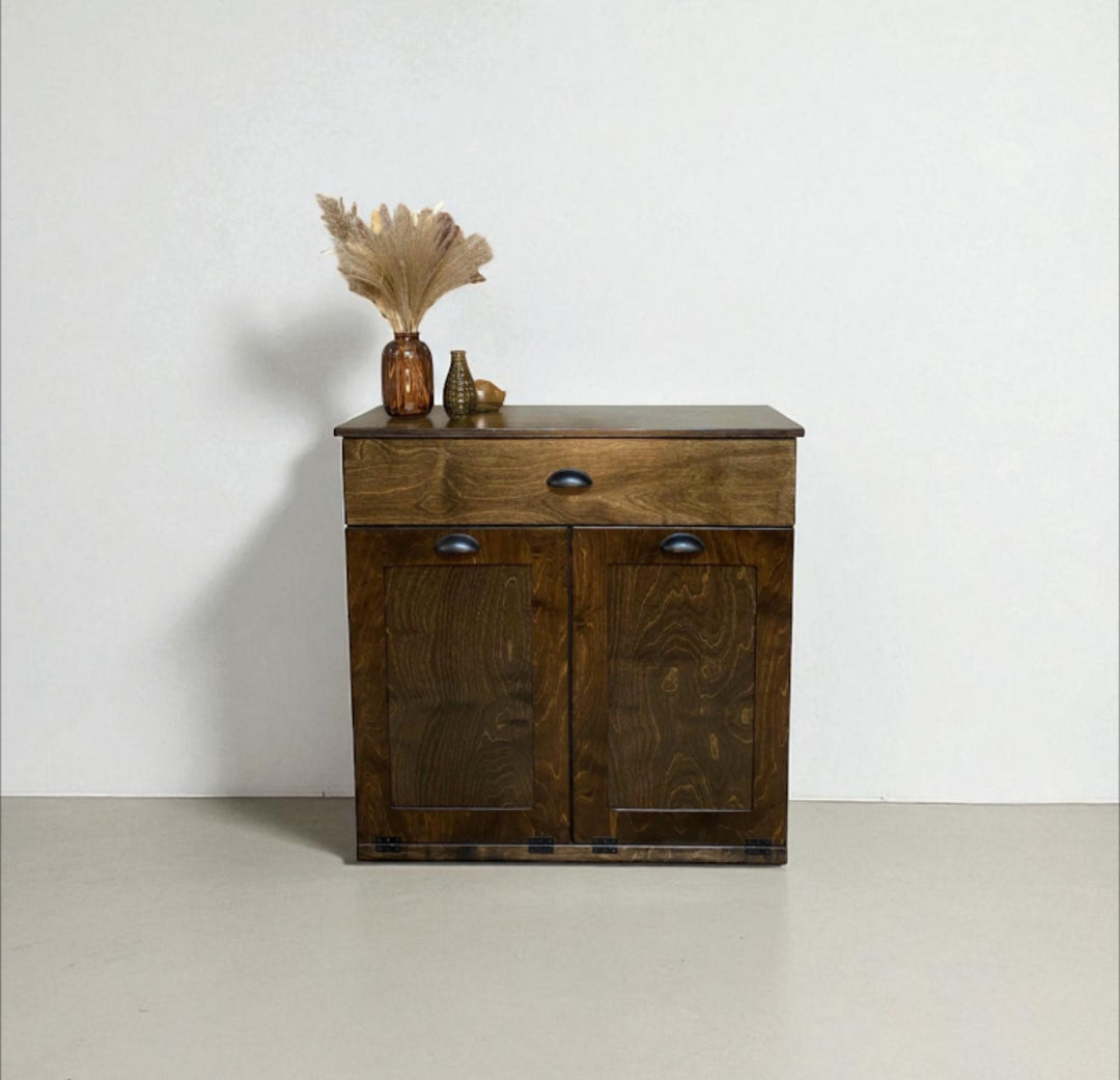 Freestanding trash cabinet with a storage drawer in dark brown stain