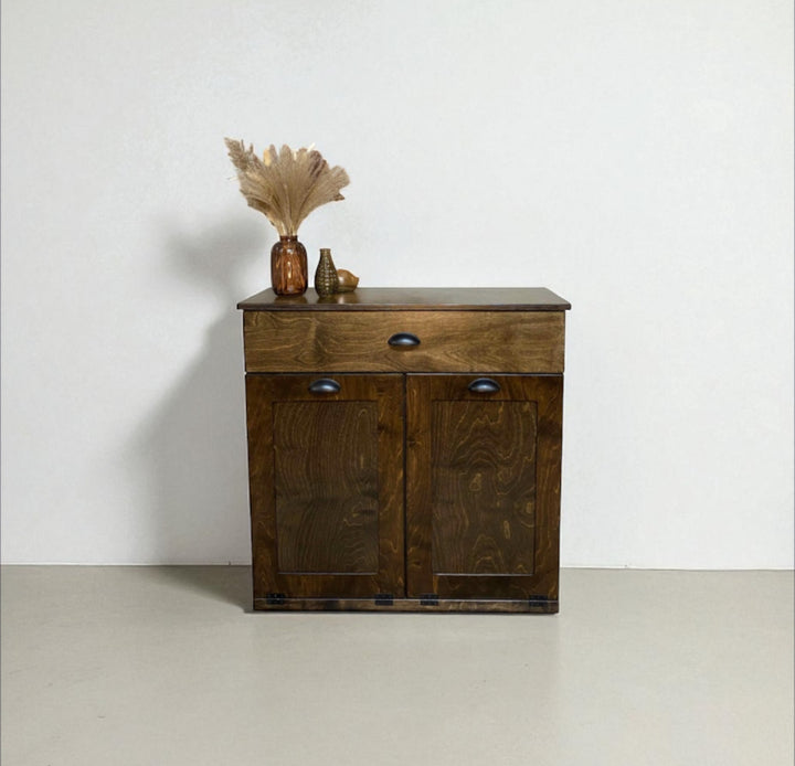 Freestanding trash cabinet with a storage drawer in dark brown stain