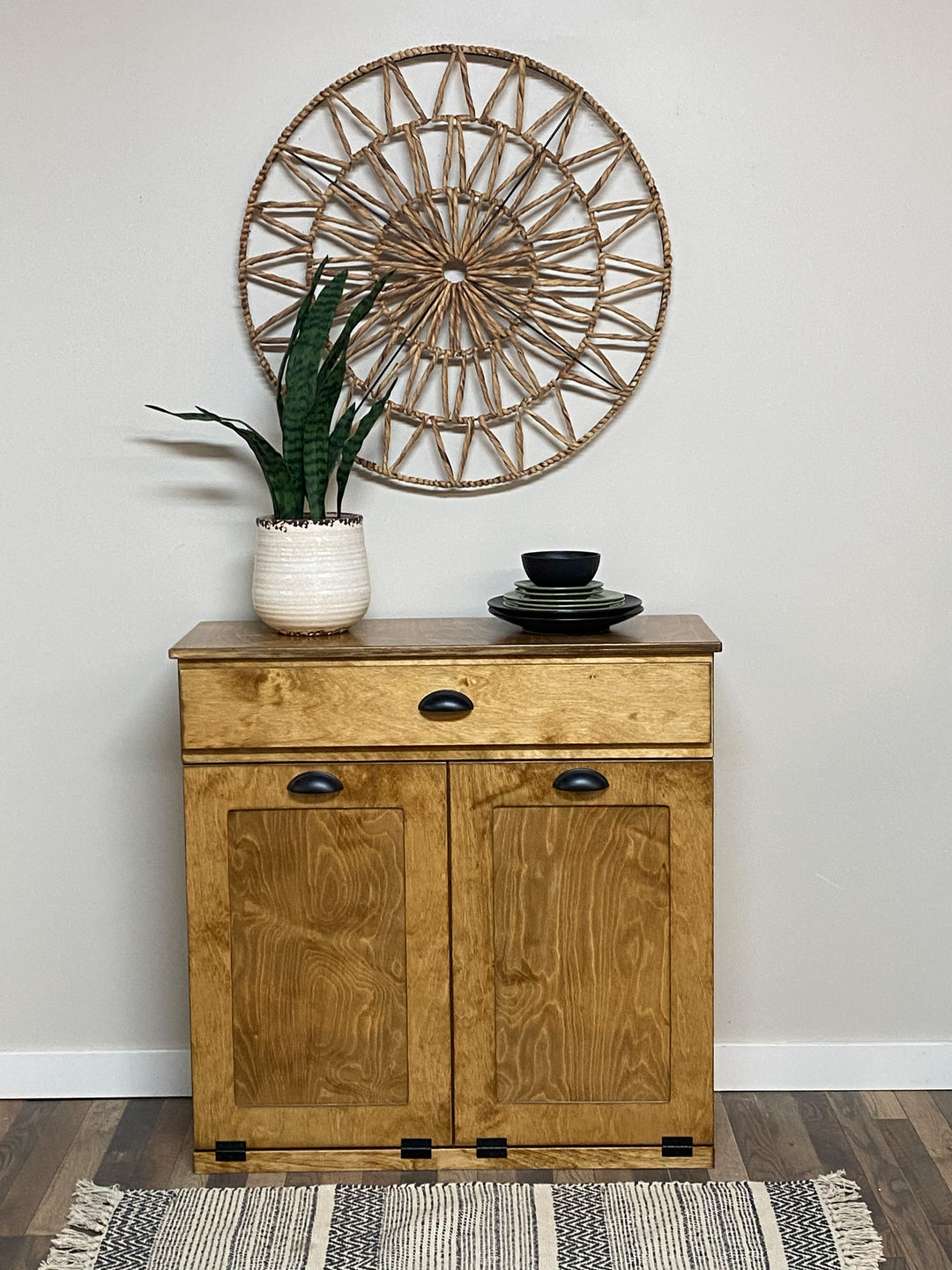 Double style trash cabinet with a storage drawer in golden oak stain