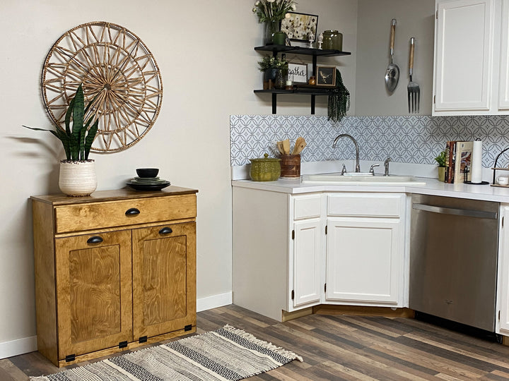 Double style trash cabinet with a storage drawer in golden oak stain
