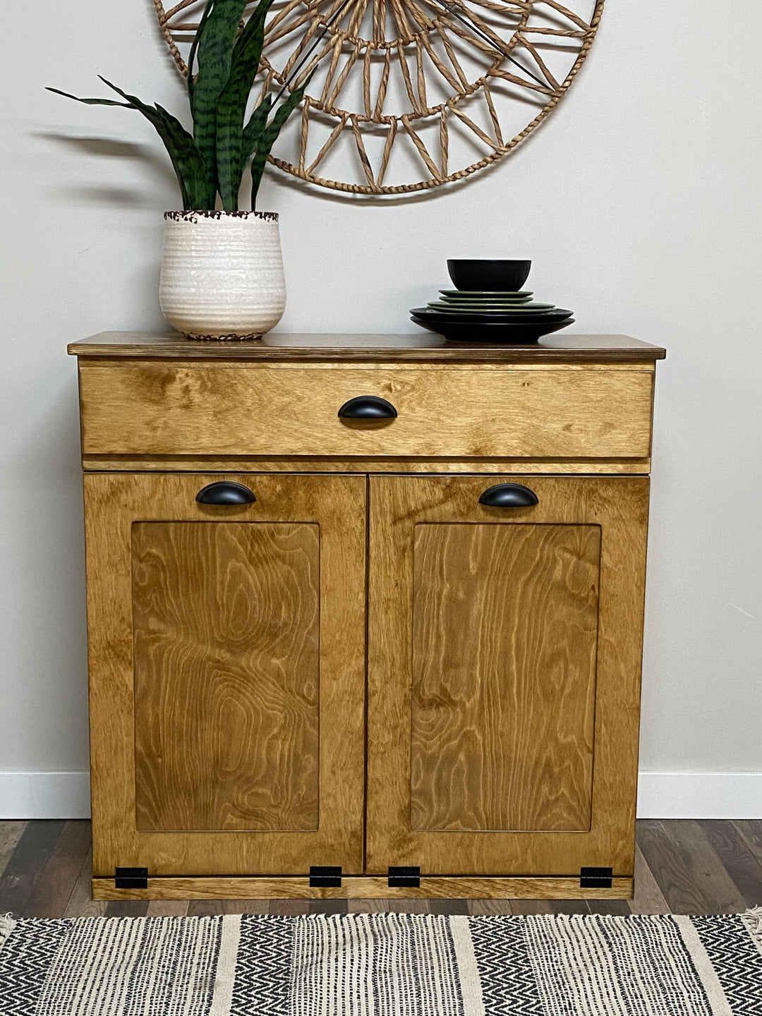 Double style trash cabinet with a storage drawer in golden oak stain