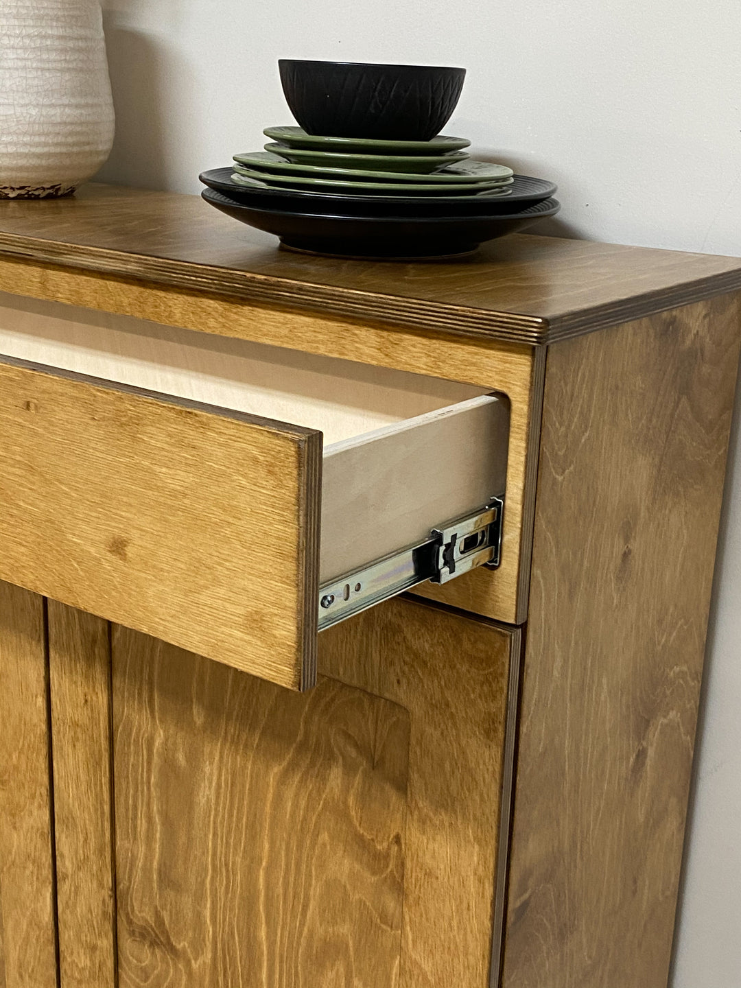 Double style trash cabinet with a storage drawer in golden oak stain