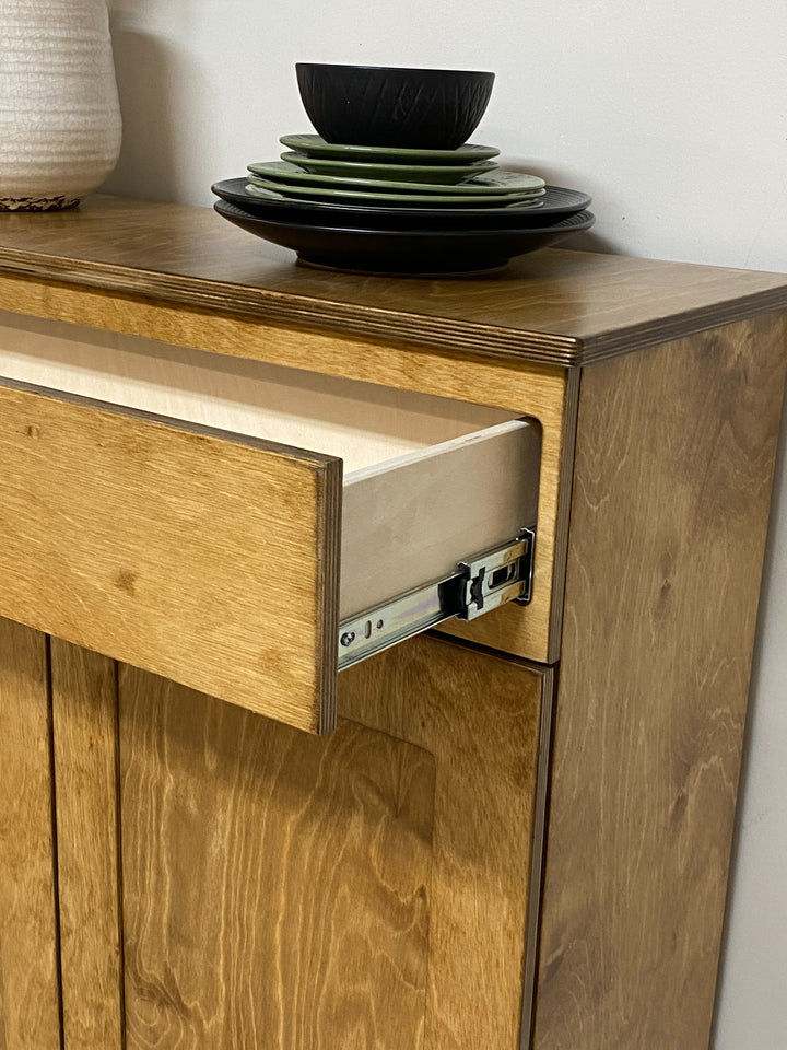 Double style trash cabinet with a storage drawer in golden oak stain