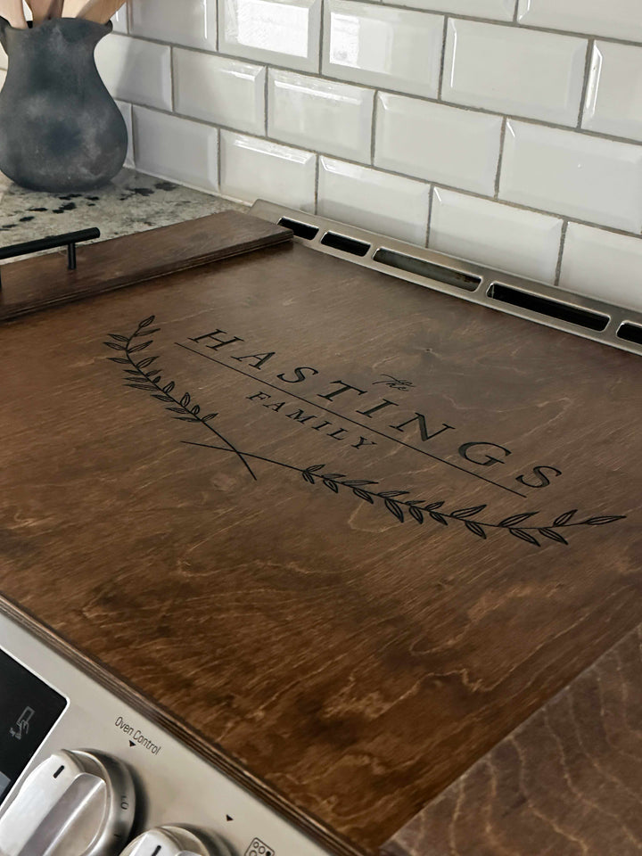 Personalized family name stove cover, warm brown + dark script "Hastings"