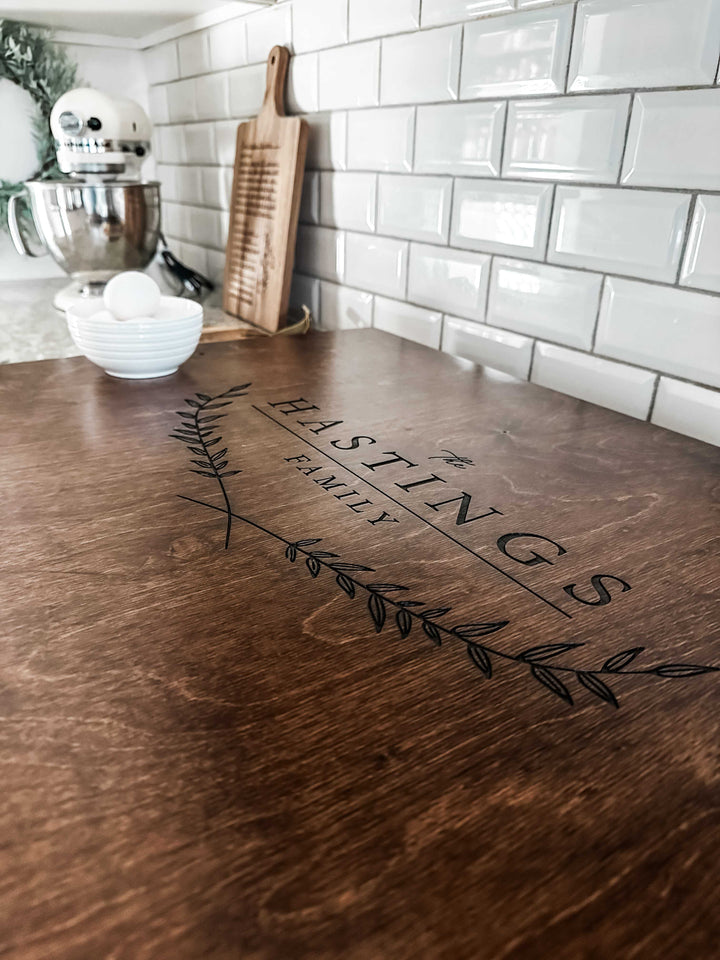 Personalized family name stove cover, warm brown + dark script "Hastings"