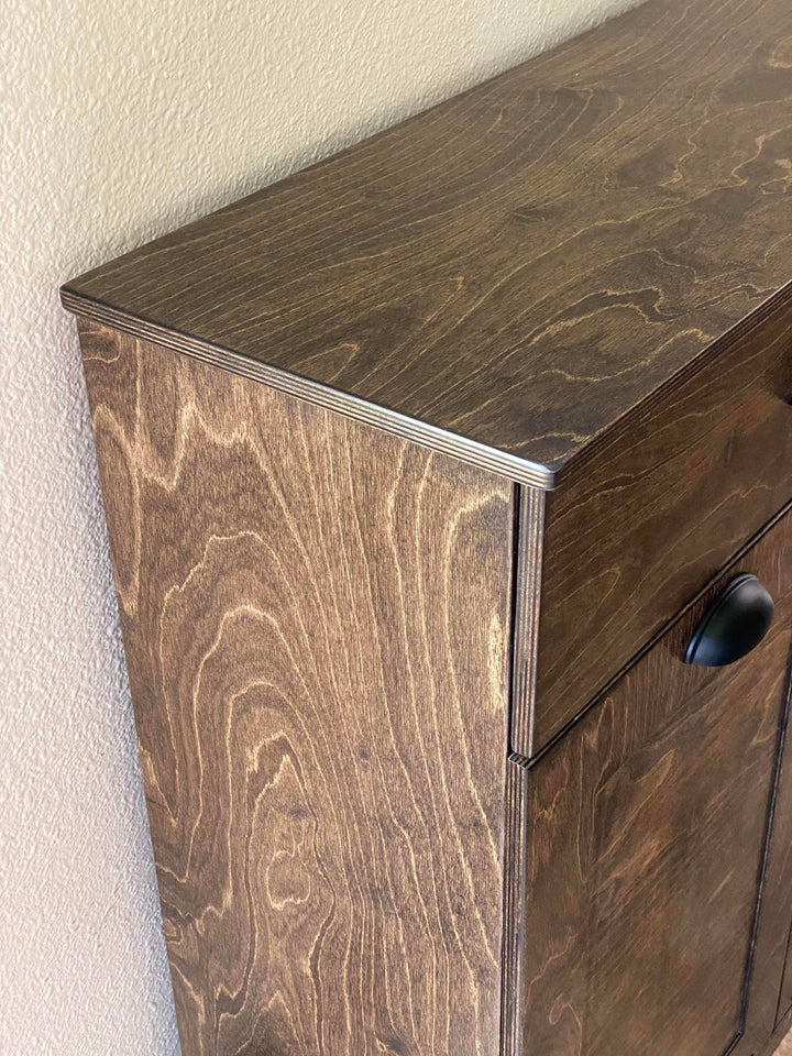 Furniture style triple tilt out trash cabinet in dark brown with a storage drawer