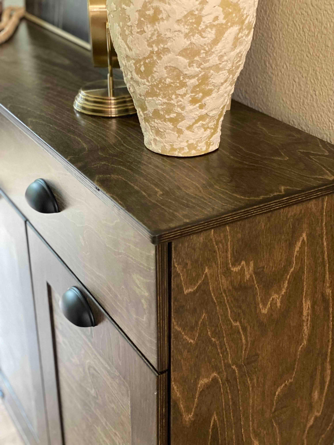 Furniture style triple tilt out trash cabinet in dark brown with a storage drawer