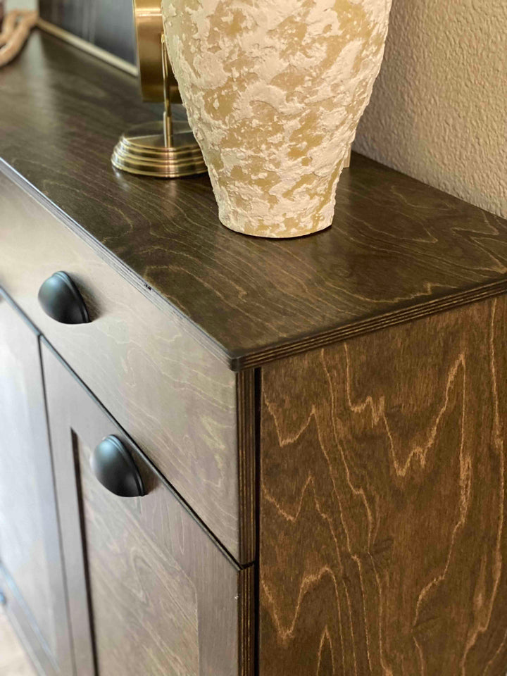 Furniture style triple tilt out trash cabinet in dark brown with a storage drawer