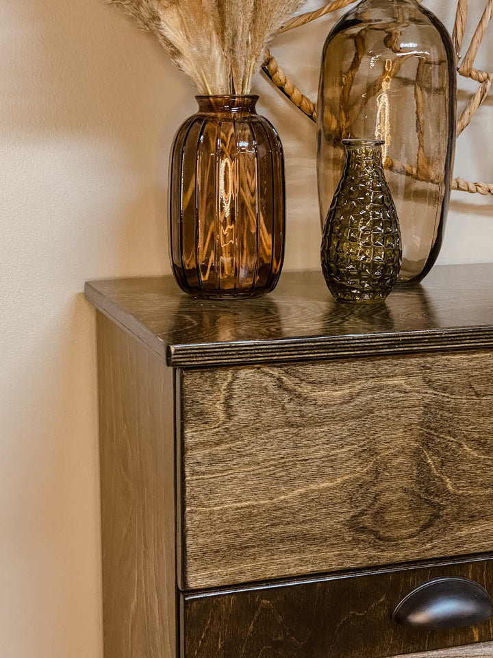 Freestanding trash cabinet with a storage drawer in dark brown stain