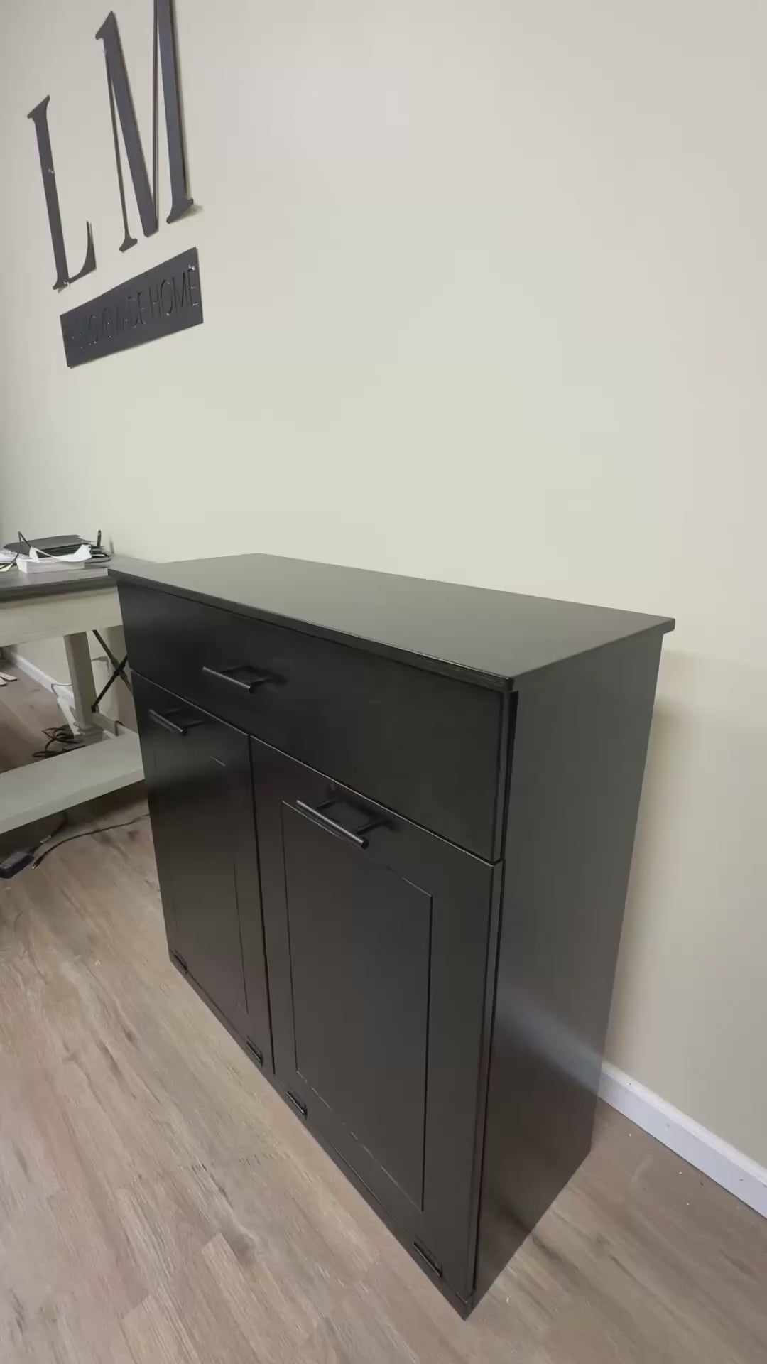 Free standing hidden trash cabinet with a storage drawer in black stain