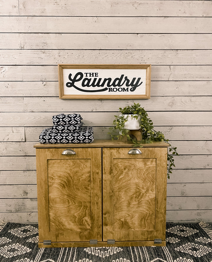 Double size golden oak tilt out laundry hamper.  Handle options are gold, silver, or black. Panel options are cedar look panel, chalkboard, barn metal, or flat front.