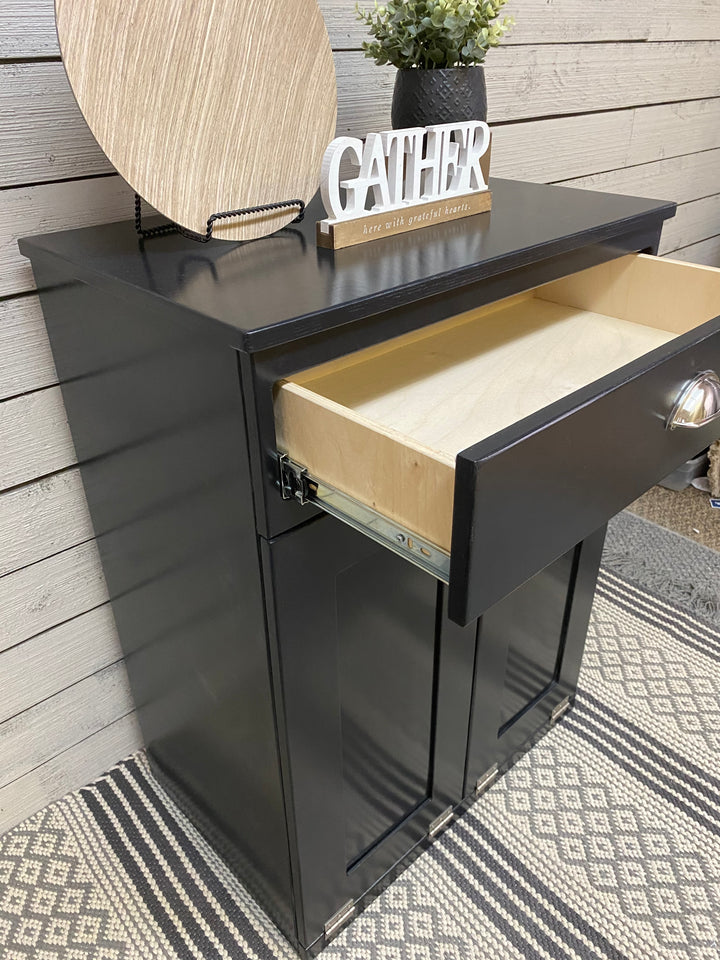 Slim style double trash cabinet with a storage drawer in black stain