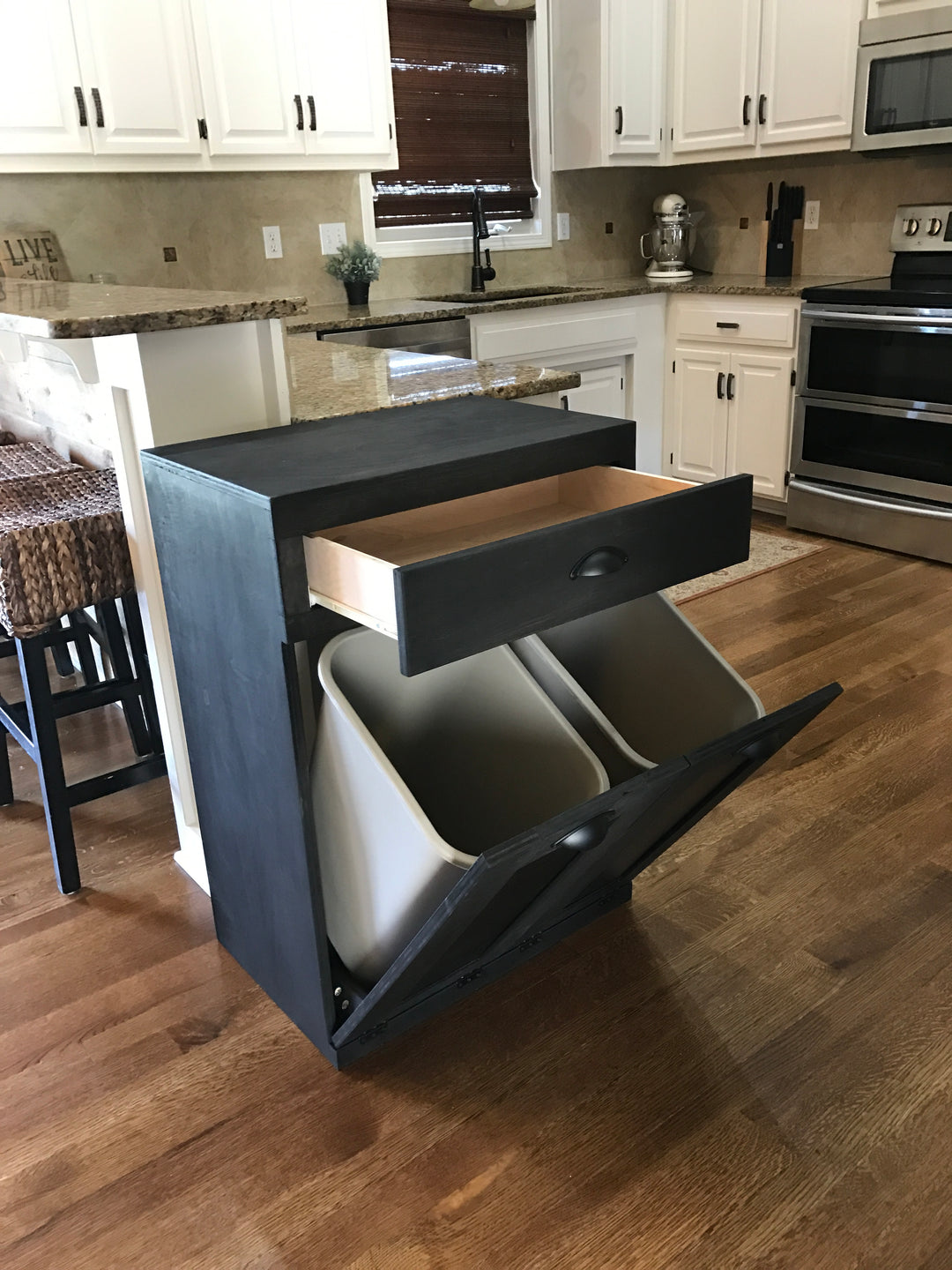 Slim style double trash cabinet with a storage drawer in black stain