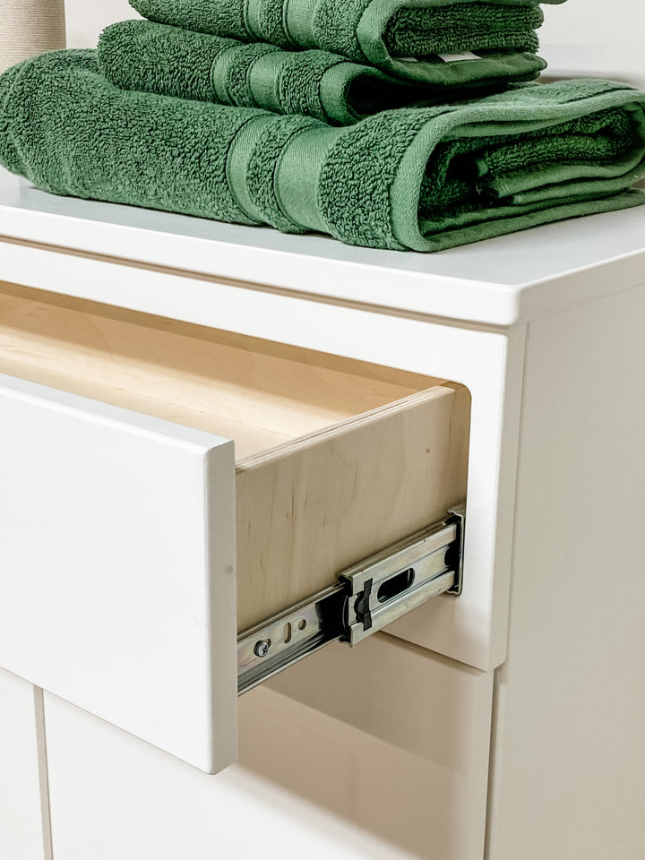 Triple counter tall laundry with a storage drawer in white
