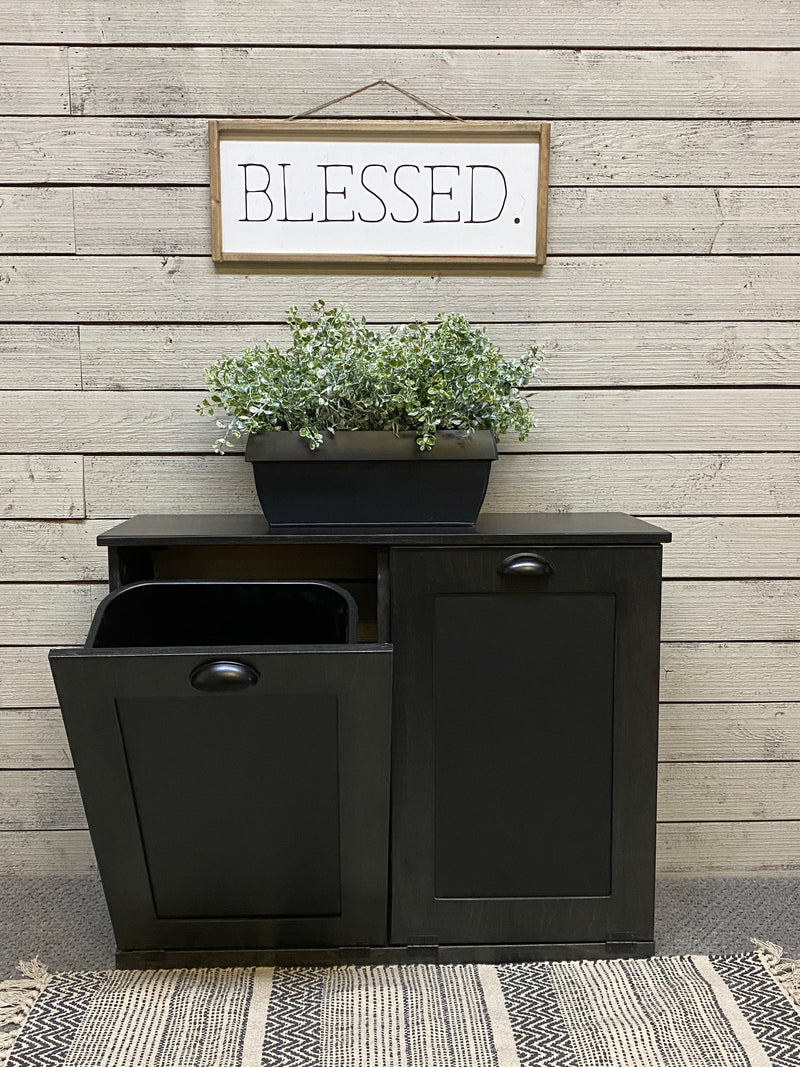 Black tilt out double size trash bin.  Handle options are gold, silver, or black. Panel options are cedar look panel, chalkboard, barn metal, or flat front.