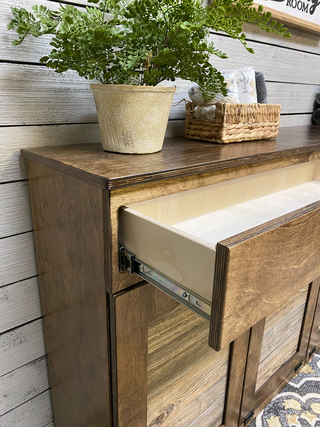 Counter tall quad trash cabinet with a storage drawer in warm brown stain
