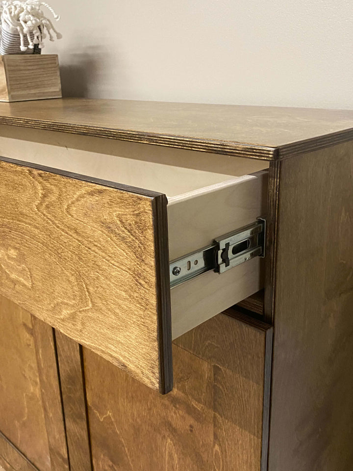 Counter tall quad trash cabinet with a storage drawer in warm brown stain