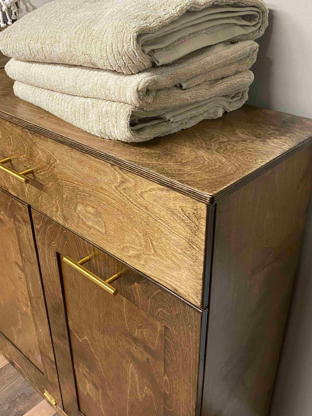 Counter tall quad trash cabinet with a storage drawer in warm brown stain